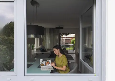 Maßgefertigter Fliegengitter-Spannrahmen SP 1/43 an einem geöffneten Fenster mit Blick in den Wohnraum